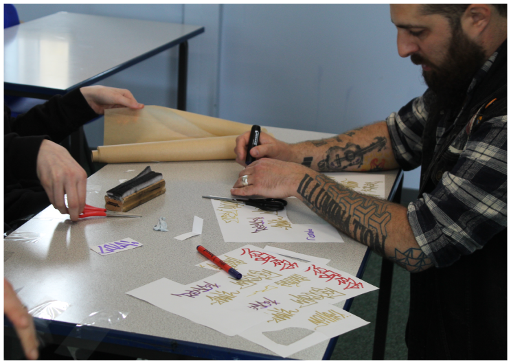 Artist Dan Walls leads a classroom session on mural art