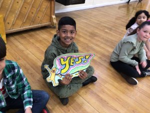 Boy holds a self-made sign saying "say YES! to ideas"